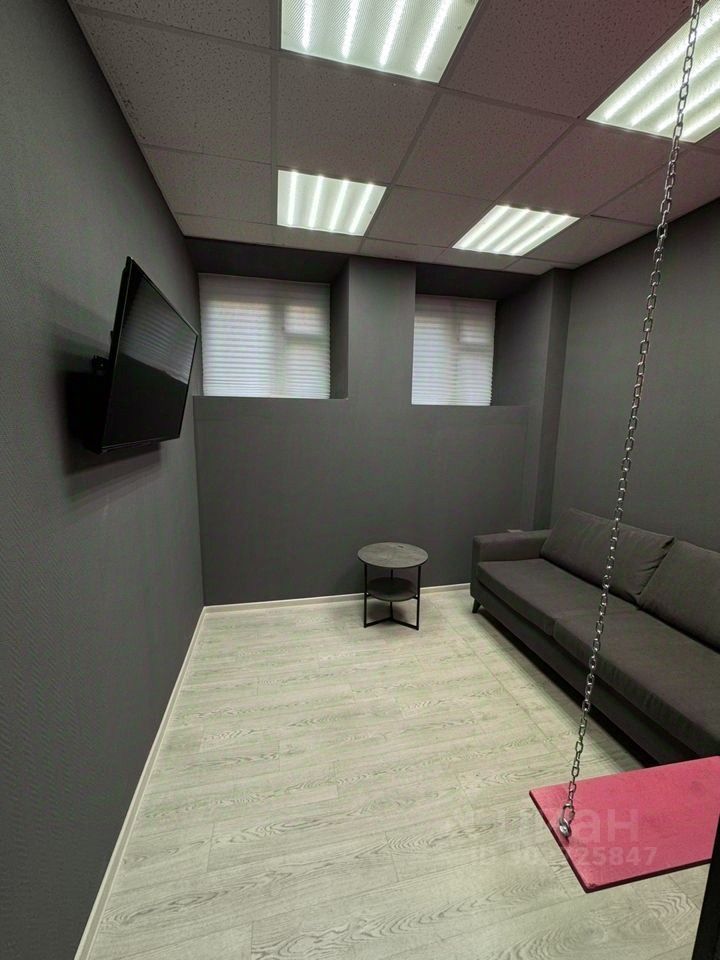 Современный офис 140 кв.м. в Екатеринбурге. Просторное помещение с серыми стенами и потолочными светильниками. Минималистичный дизайн.