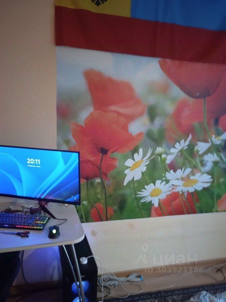 Уютная квартира в Екатеринбурге, 25 кв.м, 6 этаж. Оформление без отделки. Рабочий уголок с компьютером и цветочным декором на стене.