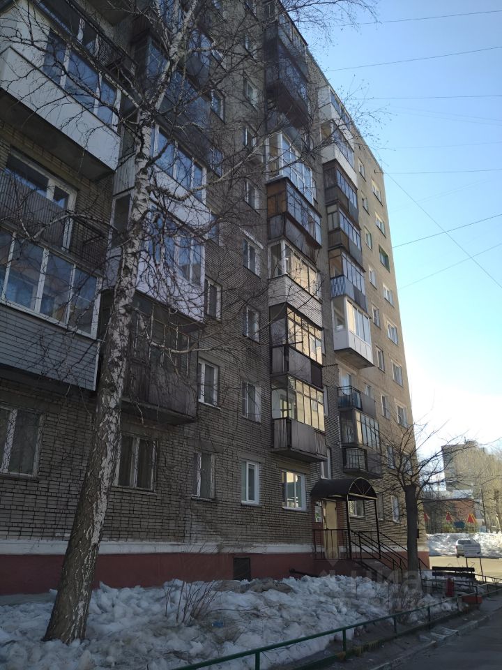 Здание выполнено в типичном советском архитектурном стиле с кирпичной кладкой и балконами. Фасад имеет несколько уровней, выделяясь большими окнами и лоджиями, что обеспечивает естественное освещение. Входная группа оформлена с навесом, что добавляет функциональности. Цветовая гамма включает светло-коричневые и серые оттенки, которые создают гармоничный вид. Использованы традиционные строительные материалы, такие как кирпич и металл для балконов. Общий вид здания демонстрирует простоту и практичность, характерные для жилых комплексов этого периода.
