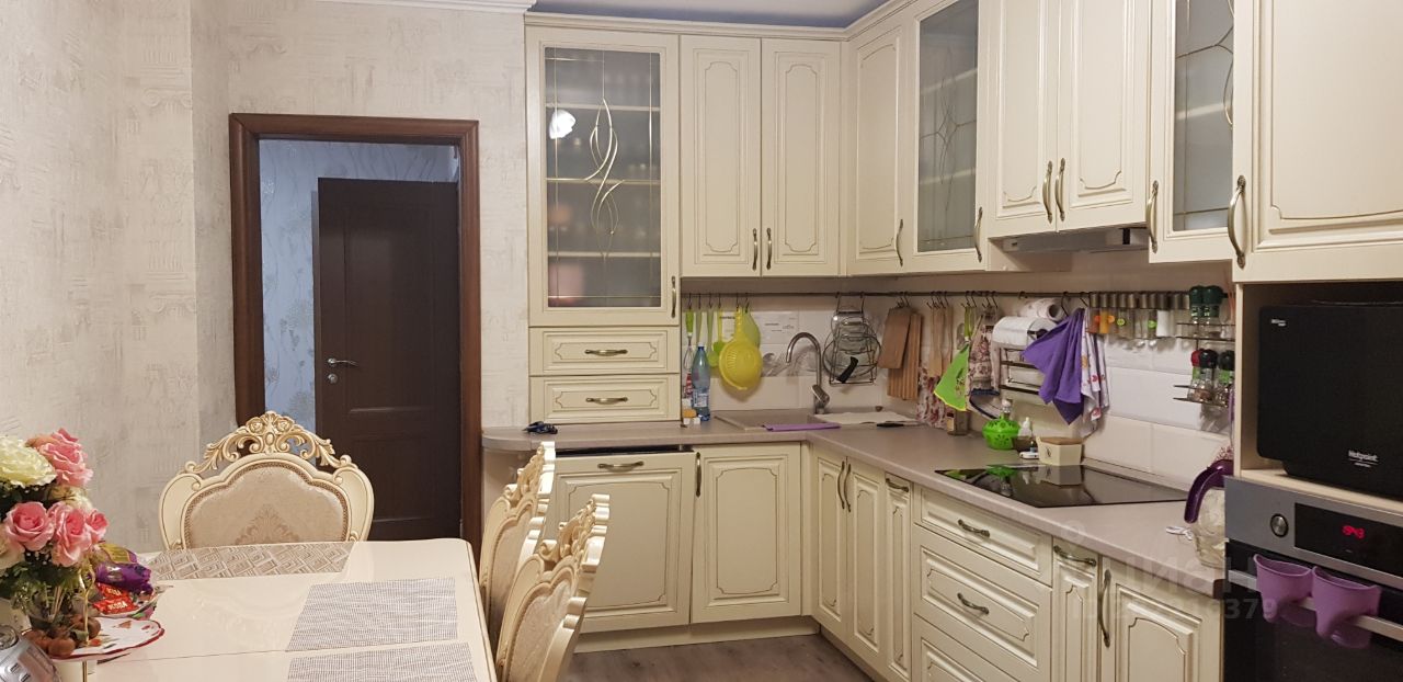 Просторная кухня 14 кв.м. с классическим интерьером, светлыми шкафами и обеденной зоной. Квартира в Екатеринбурге, 15 этаж, 2 комнаты.