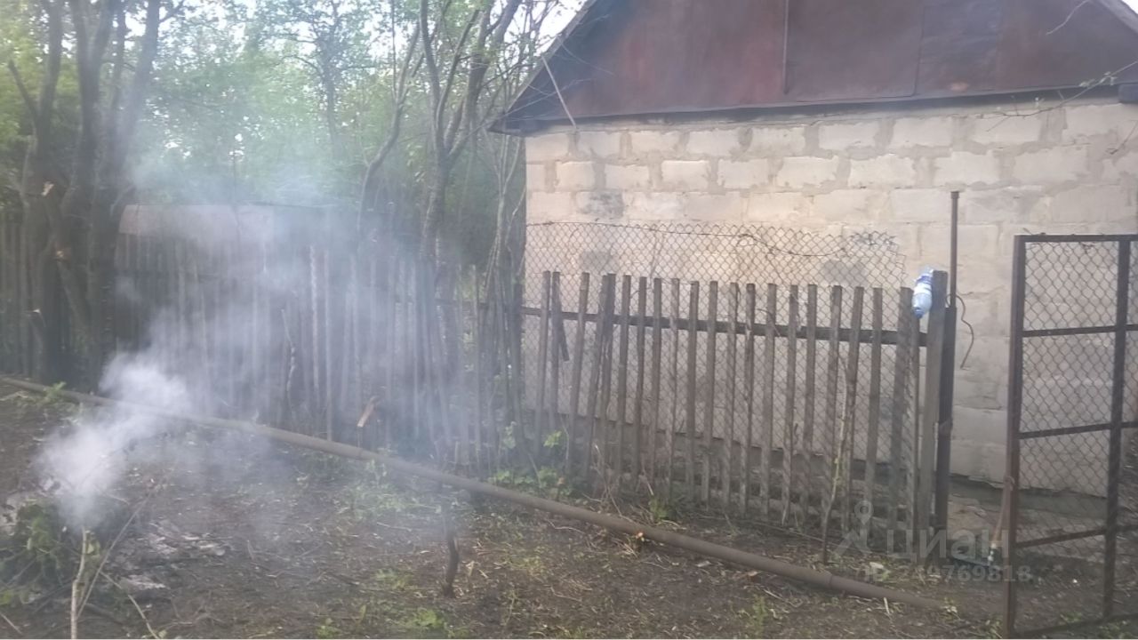 Участок в Липецке, огорожен деревянным забором, на территории есть кирпичное строение, вокруг зелёные деревья
