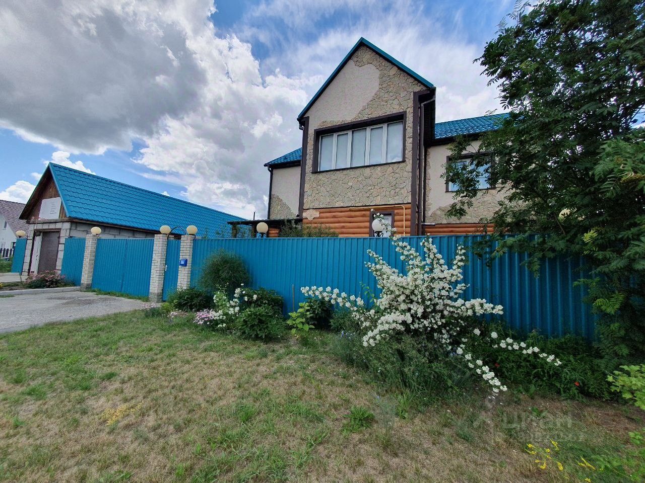 Продается дом в Барнауле, площадь 209.2 кв.м. Ухоженный двор, современный забор, красивый сад, уютный фасад.