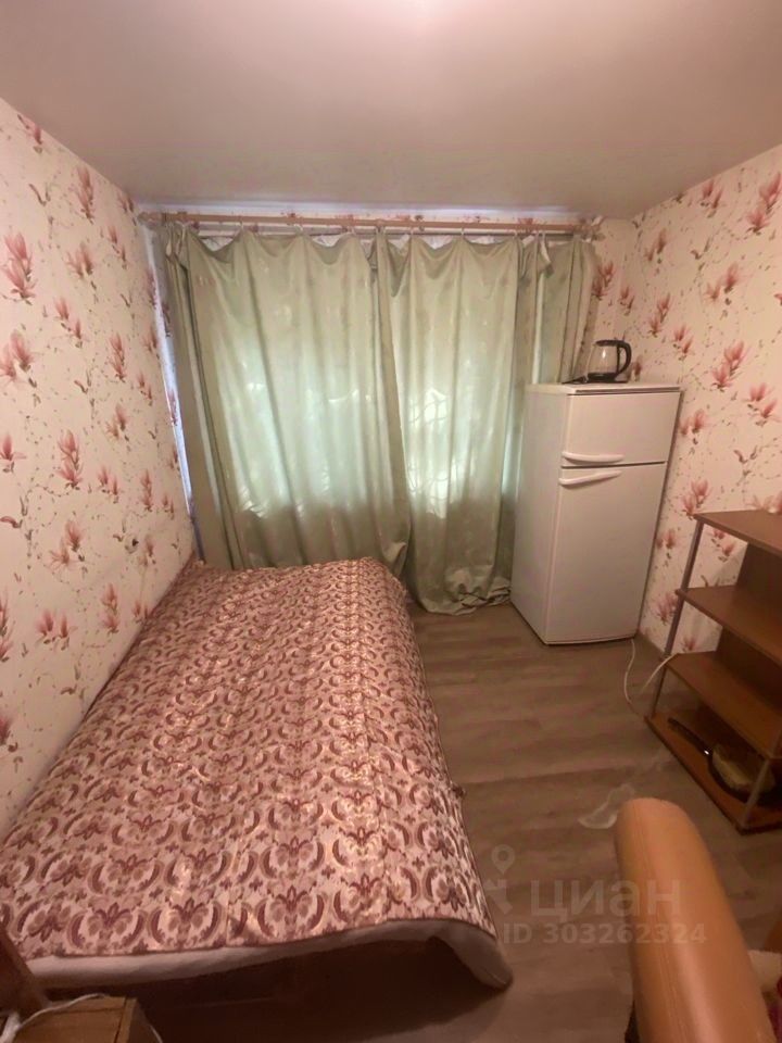 Уютная комната 15 кв.м на 2 этаже, обои с цветочным узором, холодильник, кровать, полки. Екатеринбург, 4-комнатная квартира.