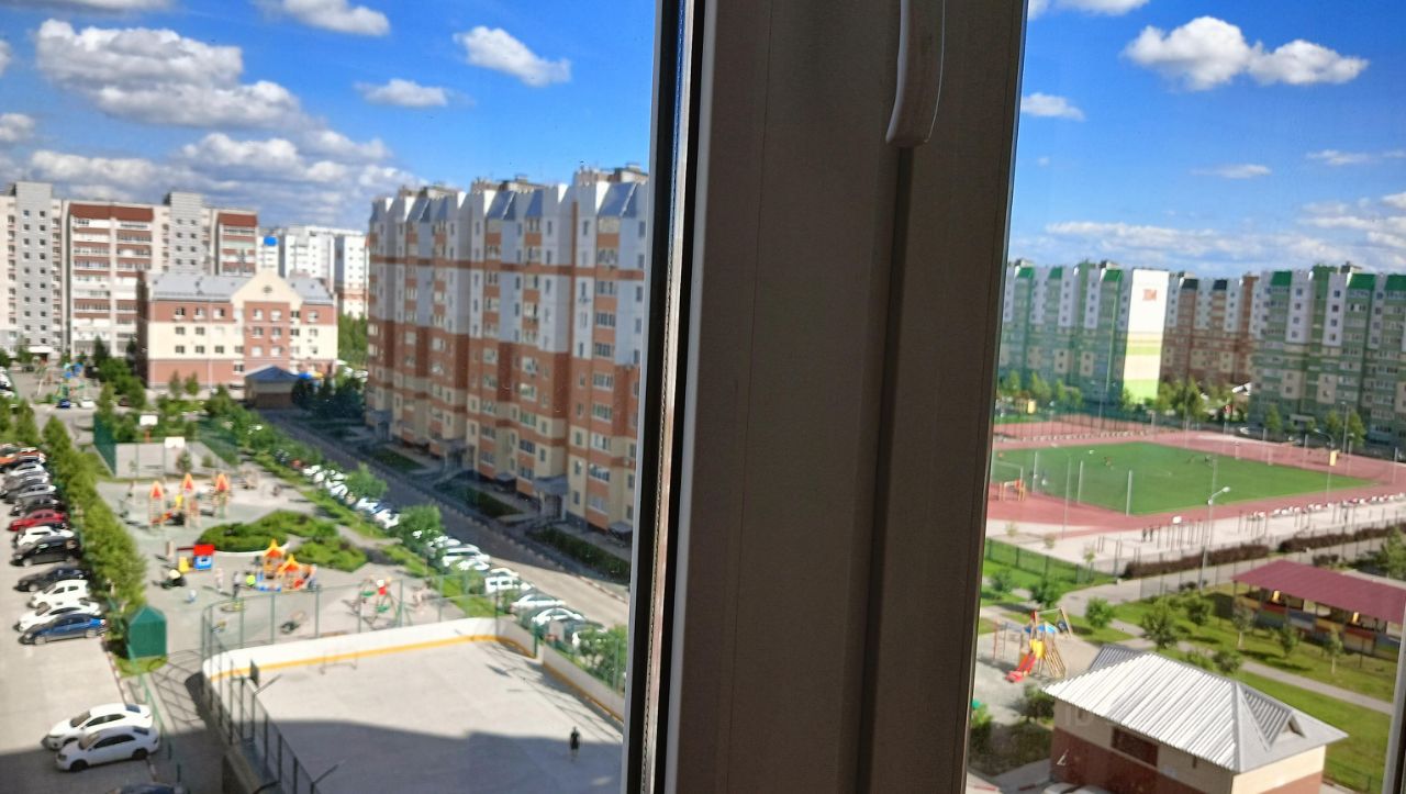 Вид из окна на ухоженный двор с детской площадкой и спортивной зоной, современные многоэтажные дома, солнечный день, 8 этаж, Барнаул