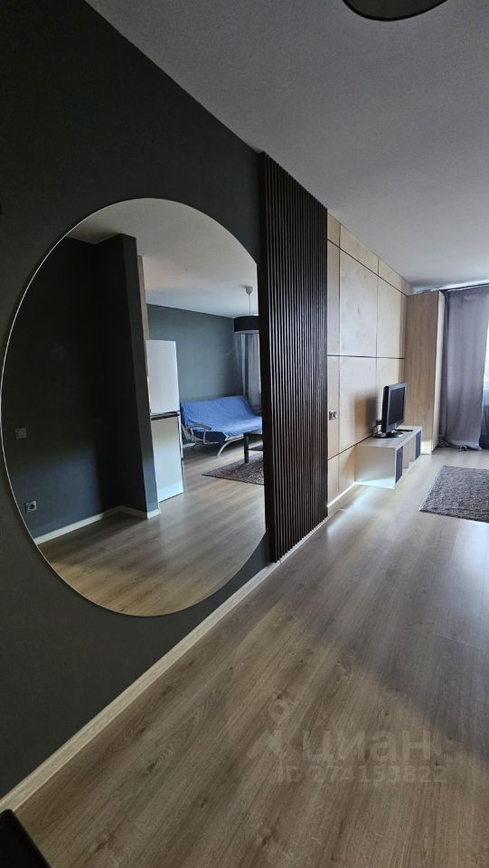 Современная квартира в Екатеринбурге, 25 кв.м, 7 этаж. Просторная гостиная с большим зеркалом и стильным интерьером.