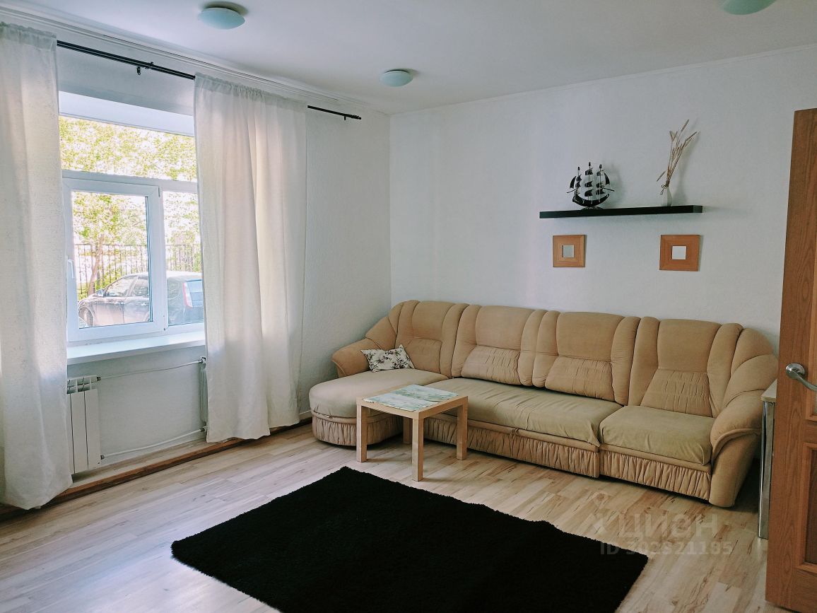Светлая 2-комнатная квартира в Екатеринбурге. Просторная гостиная с большим окном, уютный диван, современный интерьер. Площадь 65 кв.м.
