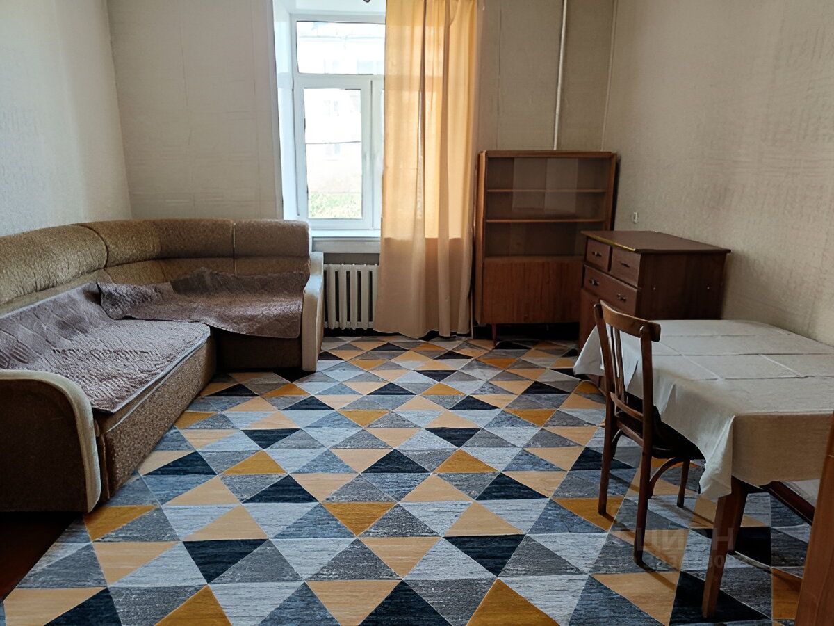 Светлая двухкомнатная квартира, второй этаж, просторная гостиная с мягким диваном, обеденный стол, уютная атмосфера. Екатеринбург, аренда.