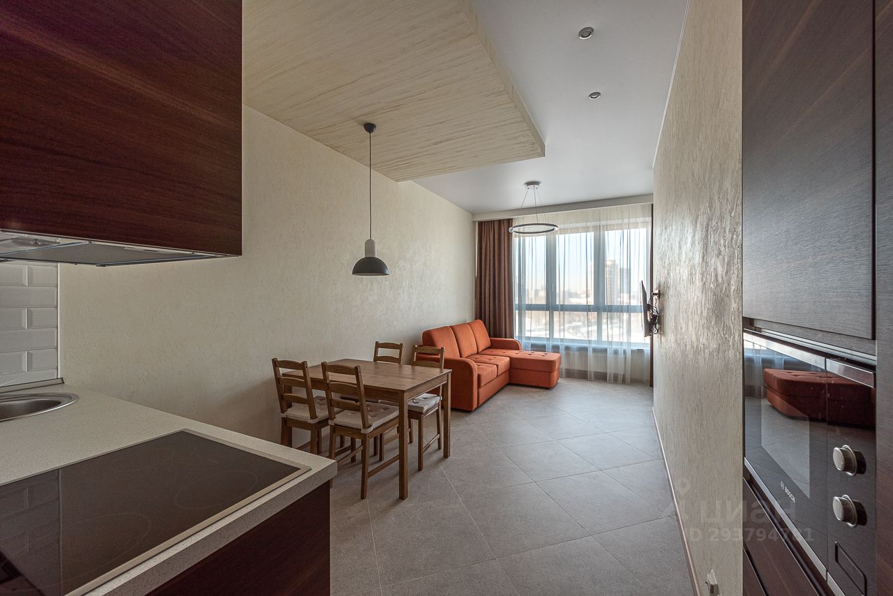 Светлая 2-комнатная квартира на 9 этаже в Екатеринбурге. Просторная гостиная с большим окном, современная кухня, уютная мебель.