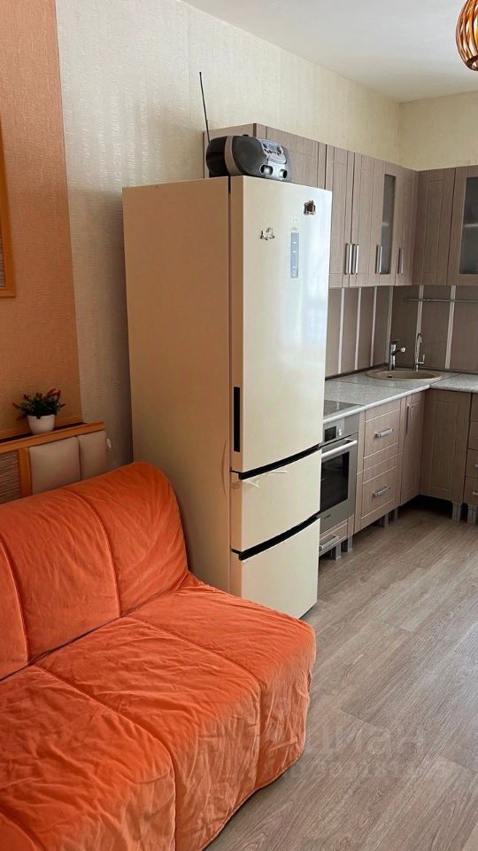 Светлая квартира с уютной кухней, холодильником и оранжевым диваном. Современные шкафы и техника. 13-й этаж, Екатеринбург.