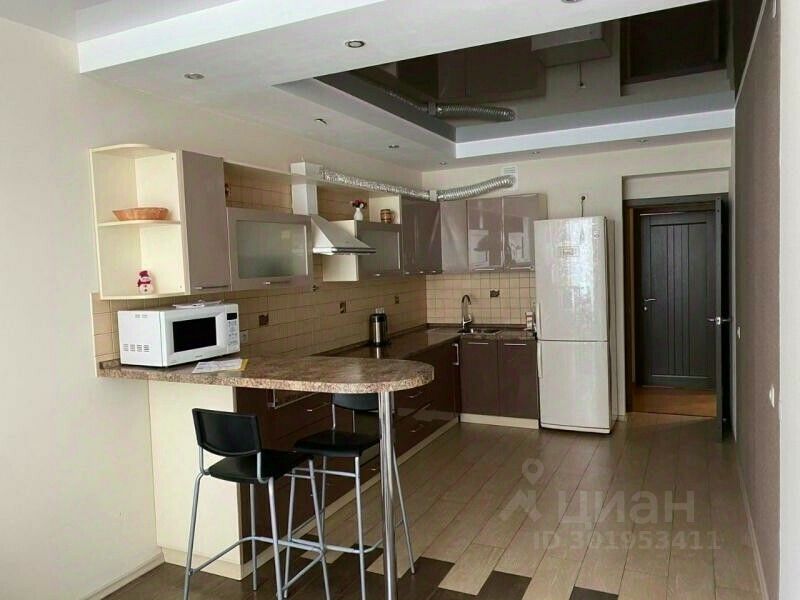 Современная кухня с барной стойкой и встроенной техникой в квартире на 18 этаже в Екатеринбурге. Просторное и светлое помещение.