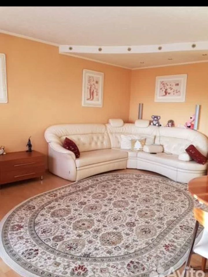 Просторная 3-комнатная квартира, 70.1 кв.м, 6 этаж, Екатеринбург. Уютная гостиная с мягким диваном и стильным ковром.