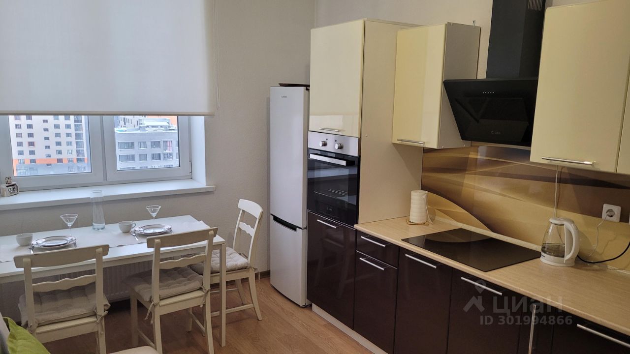 Светлая кухня с современной техникой, обеденной зоной и большим окном. Просторная и уютная, идеально подходит для комфортного проживания.