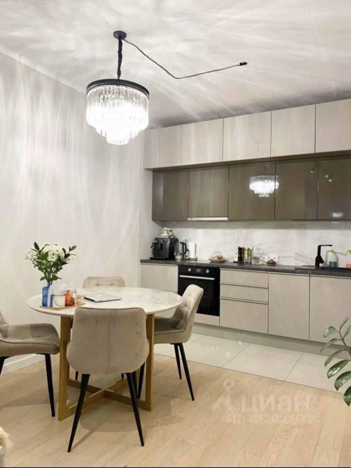 Уютная кухня с современным дизайном, обеденный стол, мягкие стулья, стильная люстра. Квартира в Екатеринбурге, 2 комнаты, 60 кв.м, 15 этаж.