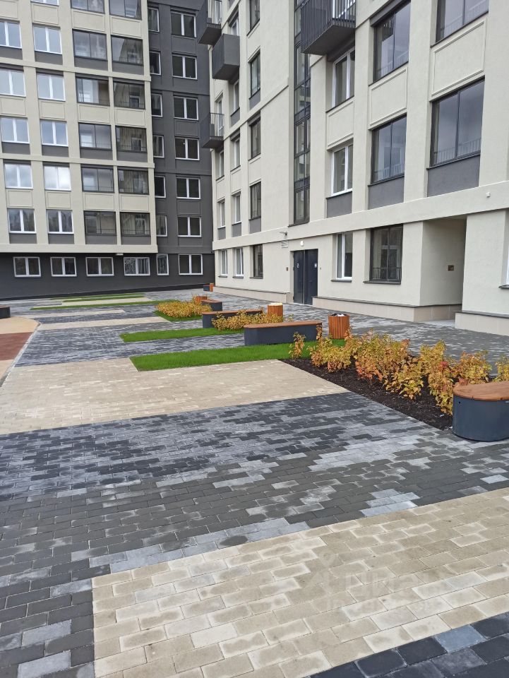 Современный жилой комплекс в Екатеринбурге. Уютный двор с зелеными насаждениями и удобными скамейками. Идеальное место для жизни.