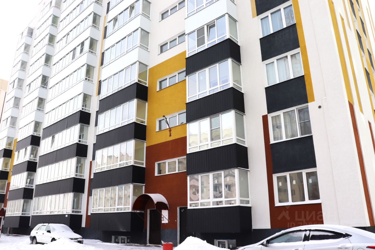 Здание выполнено в современном архитектурном стиле с яркими цветными акцентами. Фасад состоит из чередующихся черных, белых и цветных панелей, создающих динамичный визуальный эффект. Видны большие окна, обеспечивающие естественное освещение и открывающие вид на улицу. Входная группа оформлена с навесом, что добавляет уют. Материалы отделки включают гладкий бетон и текстурированные панели, создающие контраст. Цвета фасада варьируются от ярко-желтого до терракотового, что придаёт зданию современный и привлекательный вид.