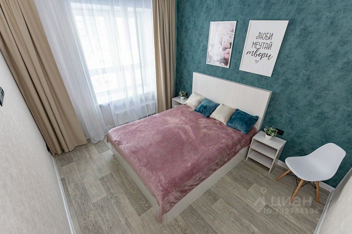 Уютная спальня с большой кроватью, стильным декором и светлыми шторами. Идеально для комфортного отдыха в Барнауле.
