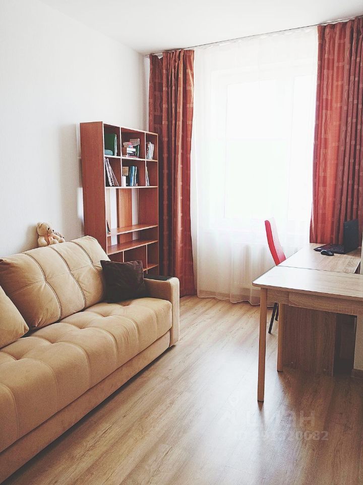 Уютная однокомнатная квартира в Екатеринбурге. Светлая комната с диваном, рабочим столом и книжным шкафом. Идеально для краткосрочной аренды.