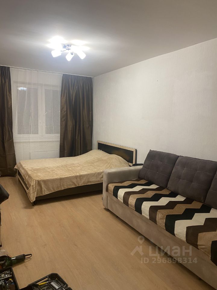 Уютная однокомнатная квартира в Екатеринбурге, 37 кв.м, 8 этаж. Просторная комната с кроватью и диваном, светлый интерьер.