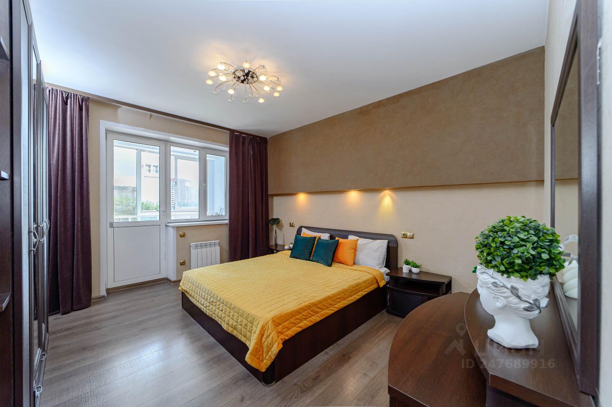 Уютная спальня с современной люстрой, большим окном и стильным декором. Просторная кровать, свежий ремонт, 5 этаж, центр Екатеринбурга.