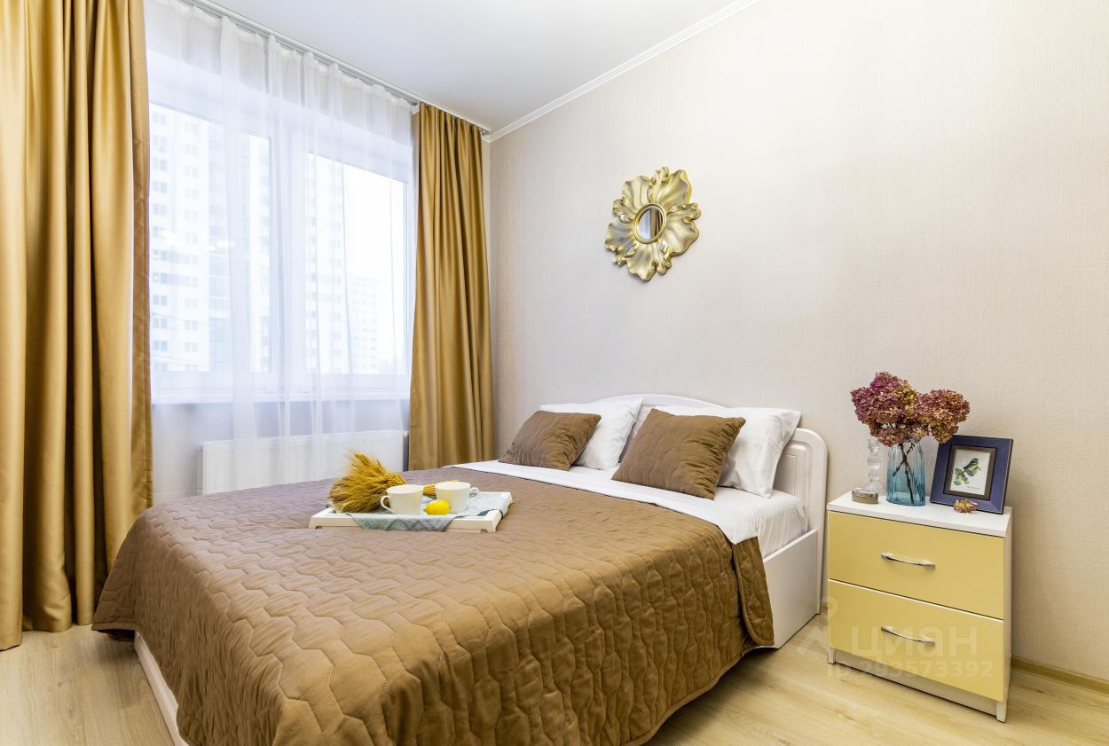 Уютная спальня с большой кроватью, стильным декором и светлыми шторами. Современная мебель и приятные цветовые решения.