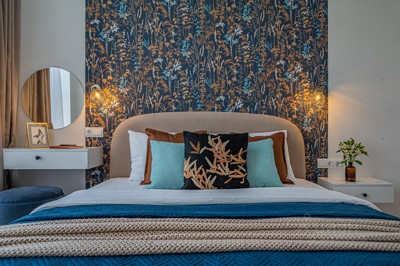 Уютная спальня с красивыми обоями, стильными подушками и современным освещением. Идеально для комфортного отдыха в Екатеринбурге.