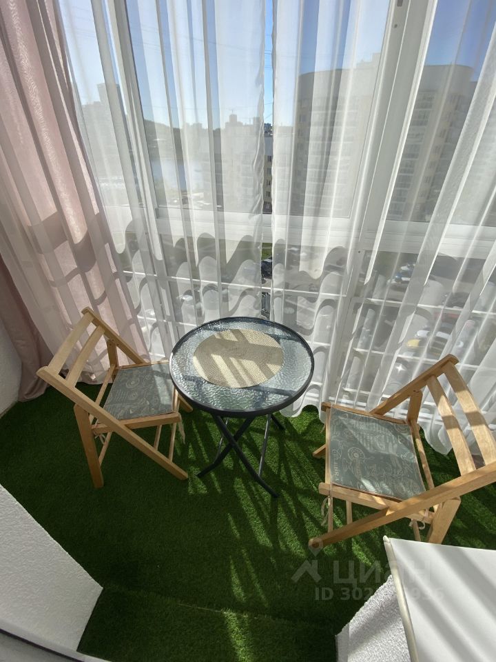 Уютный балкон с видом на город, оборудованный столиком и стульями. Отличное место для отдыха. Посуточная аренда в Екатеринбурге.