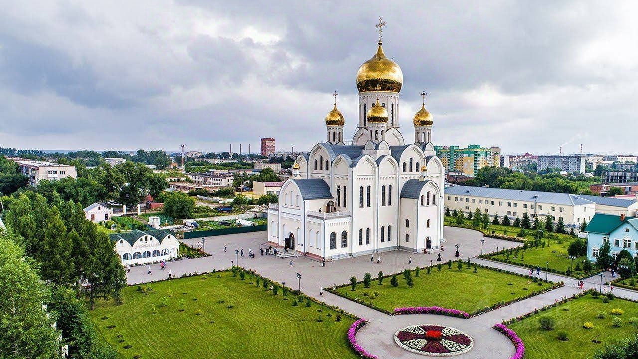 Архитектурный стиль здания представлен в виде традиционного православного храма с высокими куполами, покрытыми золотой позолотой. Структурные элементы включают массивные стены, украшенные арками и окнами с округлыми верхами. Внутри храма можно заметить просторный зал с высокими потолками, что создает ощущение величия и святости. Основные материалы – белый камень и золото, придающие зданию торжественный вид. Цветовая палитра включает белые и золотые оттенки, а отделка выполнена с акцентом на детали, что подчеркивает религиозный характер и историческую значимость сооружения.