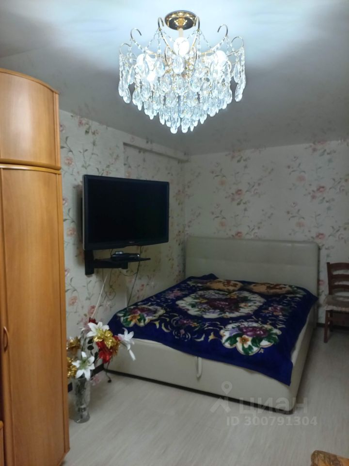 Уютная квартира в Екатеринбурге, 3 этаж, 38 кв.м, красивая люстра, цветочные обои, кровать с пледом, телевизор на стене, шкаф и декор