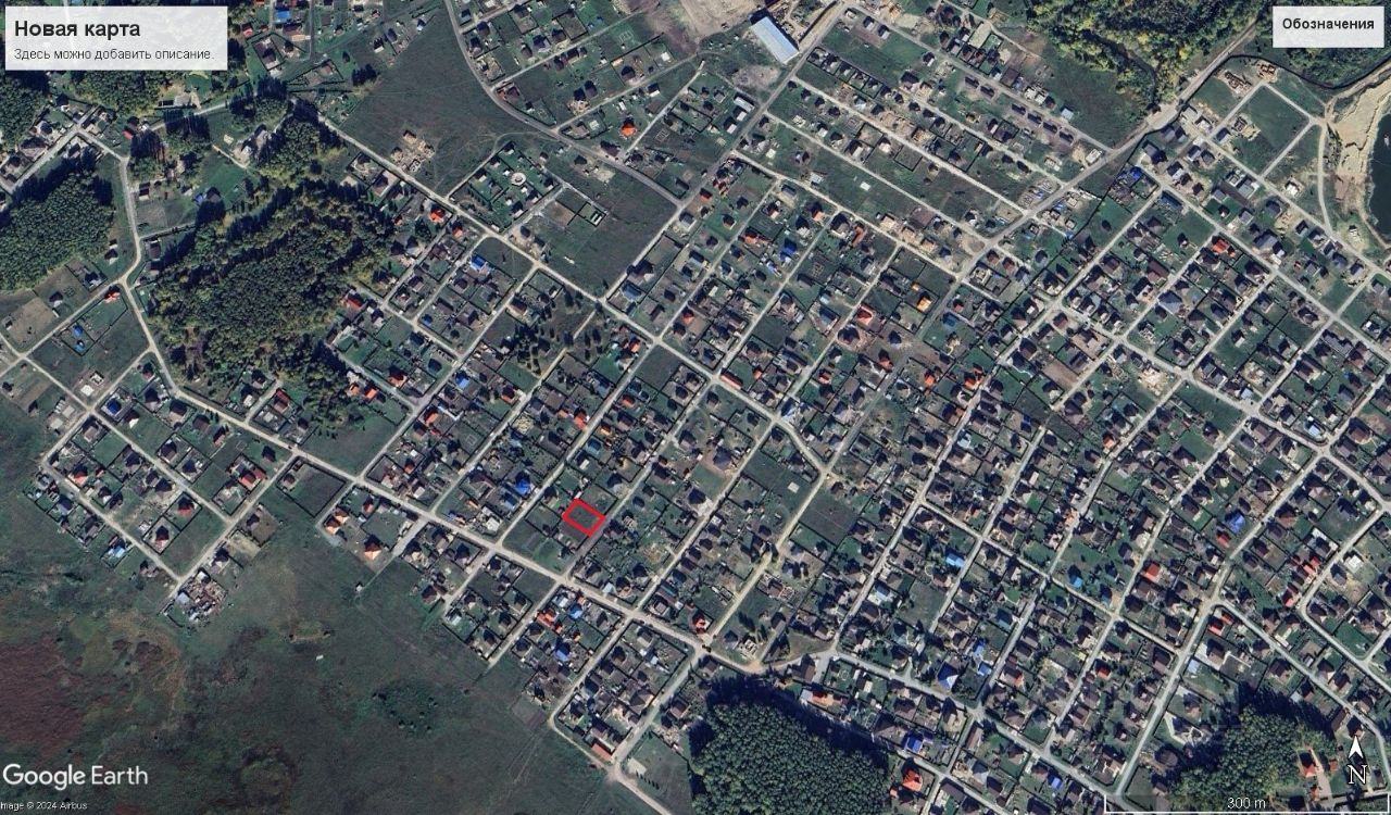 На фотографии представлена карта жилого района с четко обозначенными улицами и участками. Архитектурный стиль зданий разнообразен, включая как одноэтажные, так и двухэтажные дома. Основные структурные элементы включают аккуратные дорожки, зелёные участки и обширные дворы. Видны участки, обрамленные зеленью, что создаёт ощущение уюта. Цвета зданий варьируются от нейтральных до ярких, с акцентом на крыши, покрытые черепицей. Завершения и отделка домов выглядят аккуратно и современно, что подчеркивает общий гармоничный облик района.
