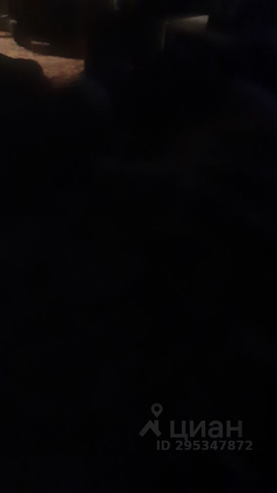 В изображении видна темная комната с мягким освещением. Архитектурный стиль и элементы дизайна нечеткие, но можно заметить наличие текстурированных стен и, возможно, деревянных деталей. Структурные особенности включают в себя открытое пространство, что создает ощущение уюта. Основные характеристики комнаты неясны из-за недостатка света, но присутствует ковер, который добавляет тепла. Материалы и отделка также неразличимы, но общий тон интерьера кажется тёмным и спокойным, создавая атмосферу уединения.